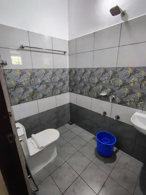 a bathroom with a toilet and a sink at Maliyeckal Homes in Viripara
