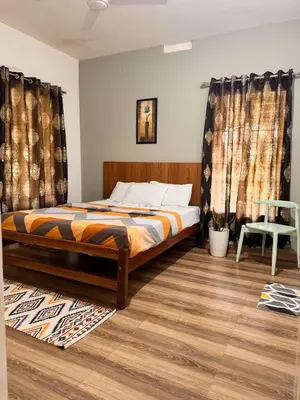 a bedroom with a bed and a chair and curtains at Malma view homestay in Kakkabe
