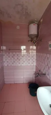 a bathroom with a sink and a pink tiled wall at Essar Cottage in Ooty