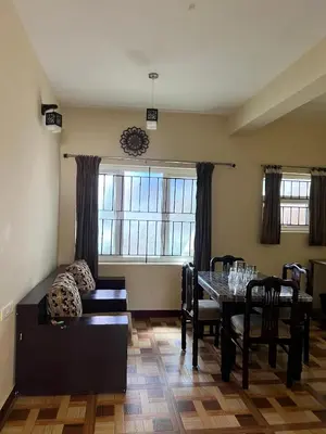 a living room with a table and a couch at Essar Cottage in Ooty
