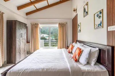 a bedroom with a large bed with orange and white pillows at Riverstone Haven in Kotagiri