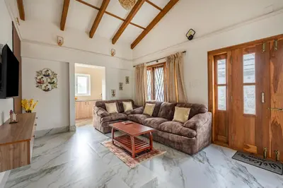 a living room with a couch and a table at Riverstone Haven in Kotagiri