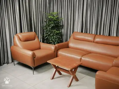 a living room with a couch and a chair at Tree Valley Resort Wayanad in Meppādi