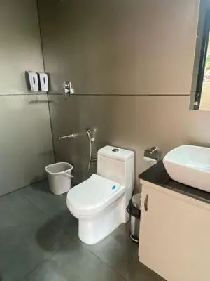 a bathroom with a white toilet and a sink at Tree Valley Resort Wayanad in Meppādi