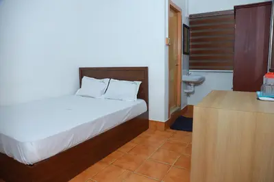 a bedroom with a bed and a sink in it at Vinayaka Tourist Home in Kozhikode