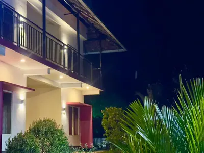 a white building with a balcony at night at Karlad Lake Palace Waterfront Resort by stayRAa in Tariyod