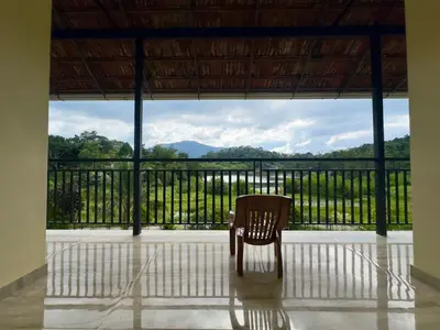 a chair sitting in the middle of a room with a view at Karlad Lake Palace Waterfront Resort by stayRAa in Tariyod