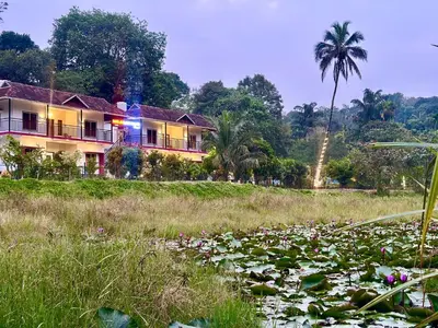 a house on a hill with a field of water lilies at Karlad Lake Palace Waterfront Resort by stayRAa in Tariyod