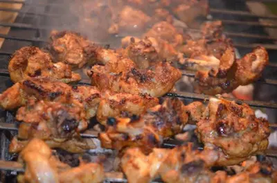 a bunch of chicken cooking on a grill at sahara dua jungle farmstay in Wayanad