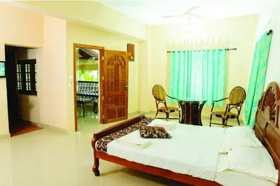 a bedroom with a bed and a table and chairs at Cybele Hill Resort in Kalpetta