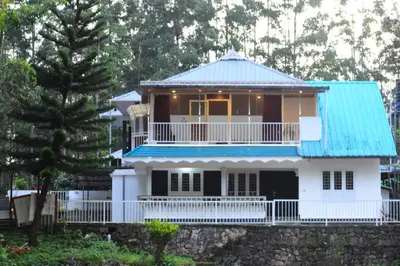 a white house with a blue roof at Brindavan Lake Resort in Munnar