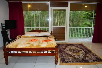 a bedroom with a bed and a large window at Brindavan Lake Resort in Munnar
