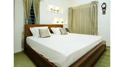 a bedroom with a large bed with white sheets and pillows at The Moon Graceful Villa in Ketti