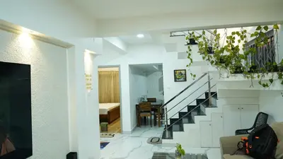 a living room with a staircase with a plant at The Moon Graceful Villa in Ketti