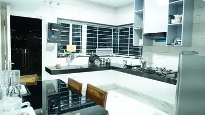 a large white kitchen with black and white appliances at The Moon Graceful Villa in Ketti