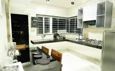 a large white kitchen with black and white appliances at The Moon Graceful Villa in Ketti