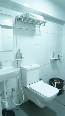a white bathroom with a toilet and a sink at The Moon Graceful Villa in Ketti