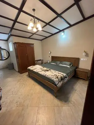 a bedroom with a bed and a chandelier at Balacalava Guest House in Coonoor
