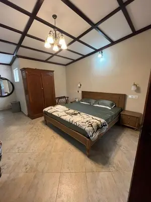 a bedroom with a bed and a chandelier at Balacalava Guest House in Coonoor