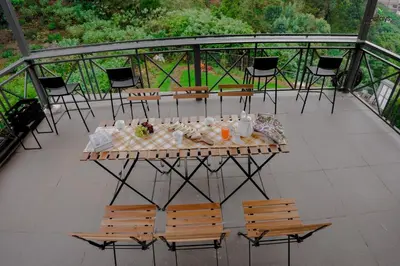 a table and chairs on top of a balcony at Hope Horizon Luxury Villa By LexStays in Coonoor