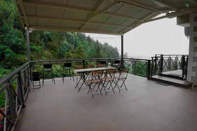 a patio with tables and chairs on a balcony at Hope Horizon Luxury Villa By LexStays in Coonoor