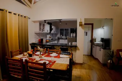 a kitchen with a table and chairs and a dining room at Hope Horizon Luxury Villa By LexStays in Coonoor