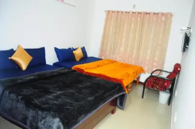 a bedroom with a blue couch and a window at A L Residency in Ooty