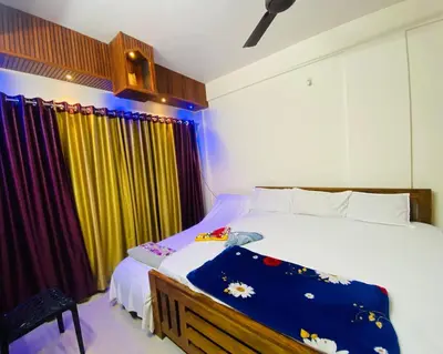 a bedroom with a bed and a yellow curtain at Flat in Guruvayur- Sooryamadhavam Apartments- Family only in Guruvāyūr