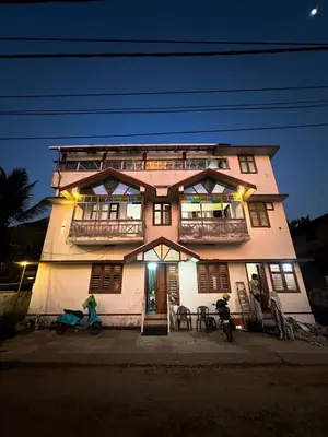 a building with two people on bikes in front of it at SeaCret by Dormer Stay in Kozhikode