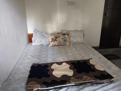 a bed with a blanket on top of it at Johnnys Destination in Angamali