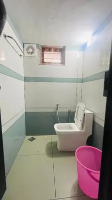 a small bathroom with a toilet and a window at Johnnys Destination in Angamali