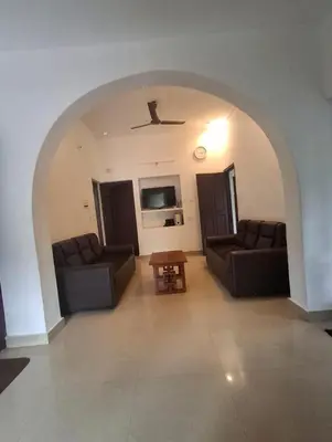 a living room with two couches and a table at Winter Valley Homestay in Vythiri