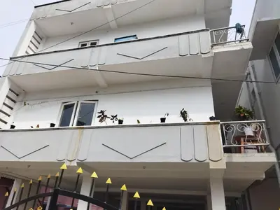a white building with a balcony with birds on it at WooLiv in Coimbatore