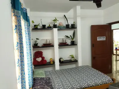 a room with a bed and shelves with potted plants at WooLiv in Coimbatore
