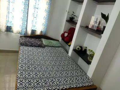a bed in a room with a window at WooLiv in Coimbatore