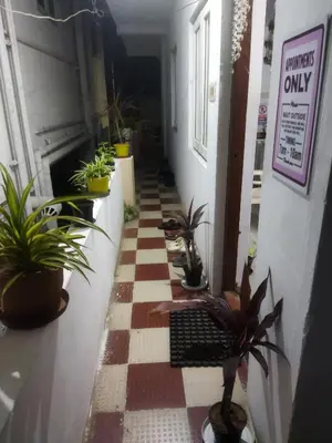 a hallway with potted plants on a checkered floor at WooLiv in Coimbatore