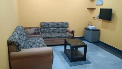 a living room with a couch and a coffee table at Charis Guest house near Guruvayur, Kunnamkulam in Kunnamkulam