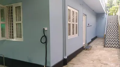 a corridor of a house with a door and stairs at Charis Guest house near Guruvayur, Kunnamkulam in Kunnamkulam