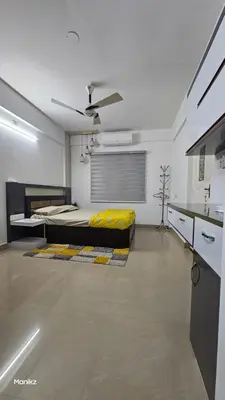 a bedroom with a bed in the middle of a room at Kulipini Family Apartment in Irinjālakuda