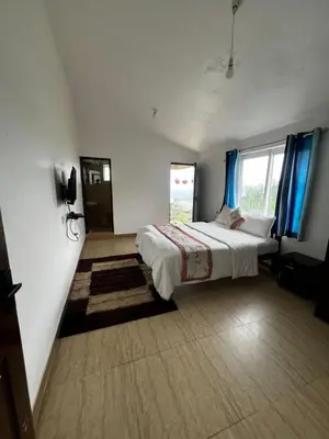 a bedroom with a large bed with blue curtains at Hideaway Home43 in Ooty
