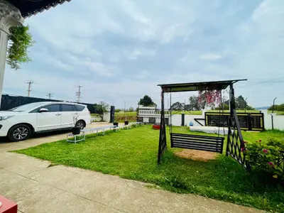 a white car parked in a yard with a gazebo at Teyt Castle - Ooty - Nilgiris in Ooty