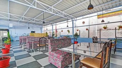 a restaurant with a table and chairs in a room at Hotel TriColors Ramnagar Gandhipuram in Coimbatore