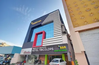 a building with a car parked in front of it at Hotel TriColors Ramnagar Gandhipuram in Coimbatore
