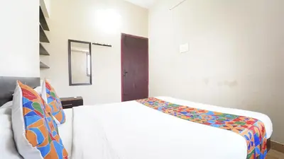 a bedroom with a white bed with a colorful blanket at Airport Home Stay in Coimbatore