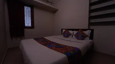 a bedroom with a large bed with pillows and a window at Airport Home Stay in Coimbatore