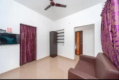a living room with a couch and a ceiling fan at Airport Home Stay in Coimbatore