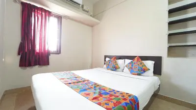 a bedroom with a large white bed with a window at Airport Home Stay in Coimbatore