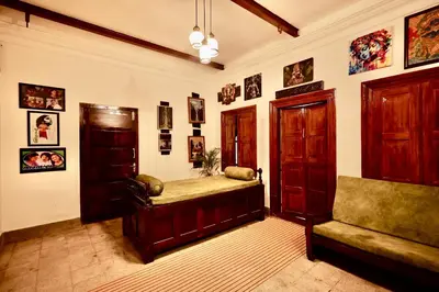 a living room with a couch and pictures on the wall at Idanazhi the corridor in Kozhikode