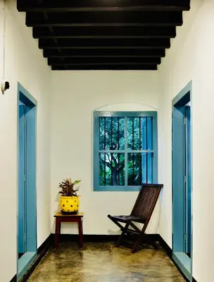 a room with a chair and a window at Idanazhi the corridor in Kozhikode