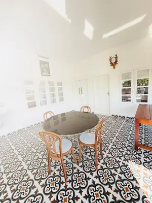 a living room with a table and chairs on a rug at Paradise Premium Villa Munnar in Munnar